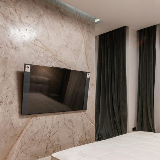 Spacious contemporary bedroom featuring a mounted TV and minimalist design.