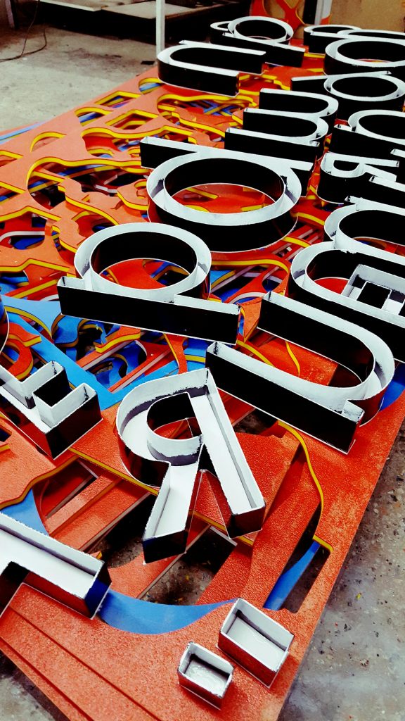 Vibrant neon letters arranged artistically, showcasing a unique signage design.