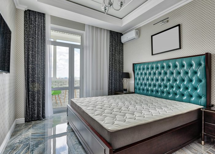 Modern bedroom interior featuring a large bed and balcony access. Stylish and serene.